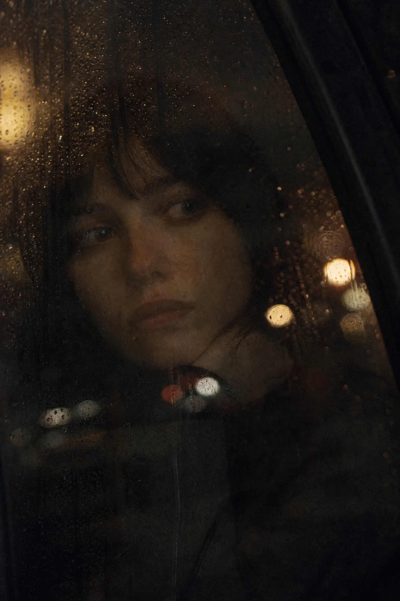 电影海报：雨‌夜窗前的女性面孔